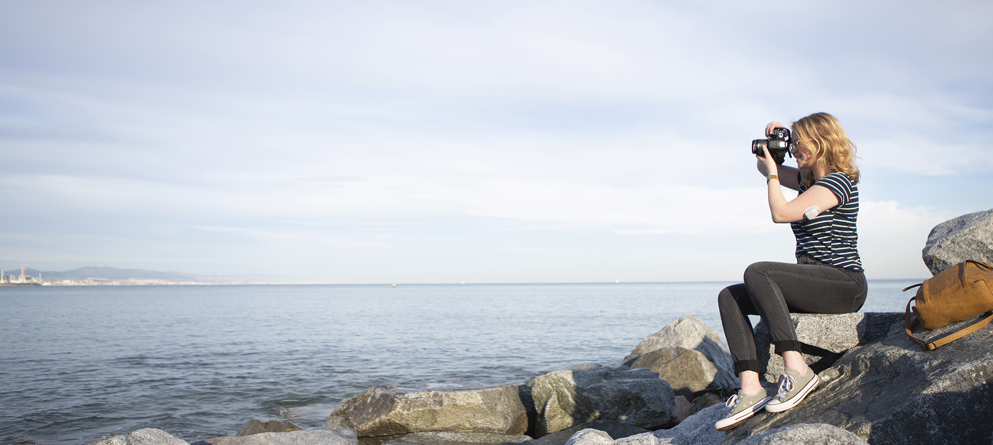 Omnipod - Podder, Myrthe, sitting on rocks by ocean taking photos