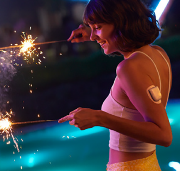 Woman holding sparklers with a pod on her left arm