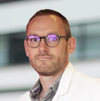 Headshot photo of Professor Michael Joubert in white coat and wearing glasses