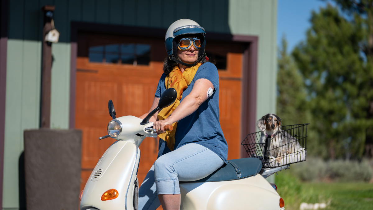 Omnipod 5 Podder Dr. Eden Miller riding a moped while wearing a helmet on her head