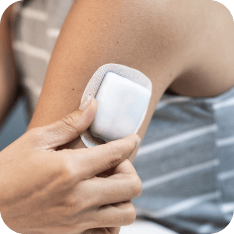 Person placing an Omnipod Pod on their left arm