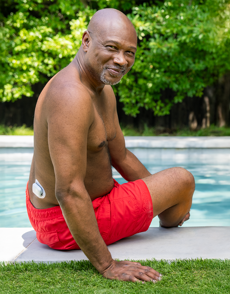 Omnipod Podder sitting by pool with a Pod on his lower right back