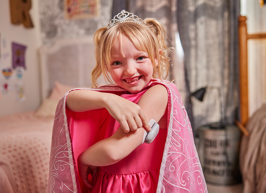 Omnipod Podder Romey in a pink outfit showing off her Pod on her left arm