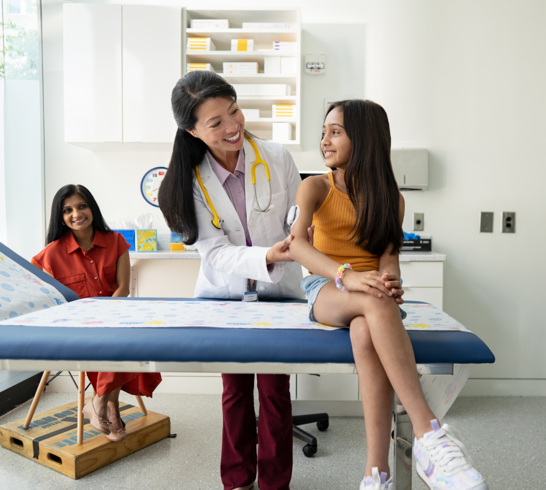 HCP with mother and daughter in exam room looking at Pod on daughter's arm