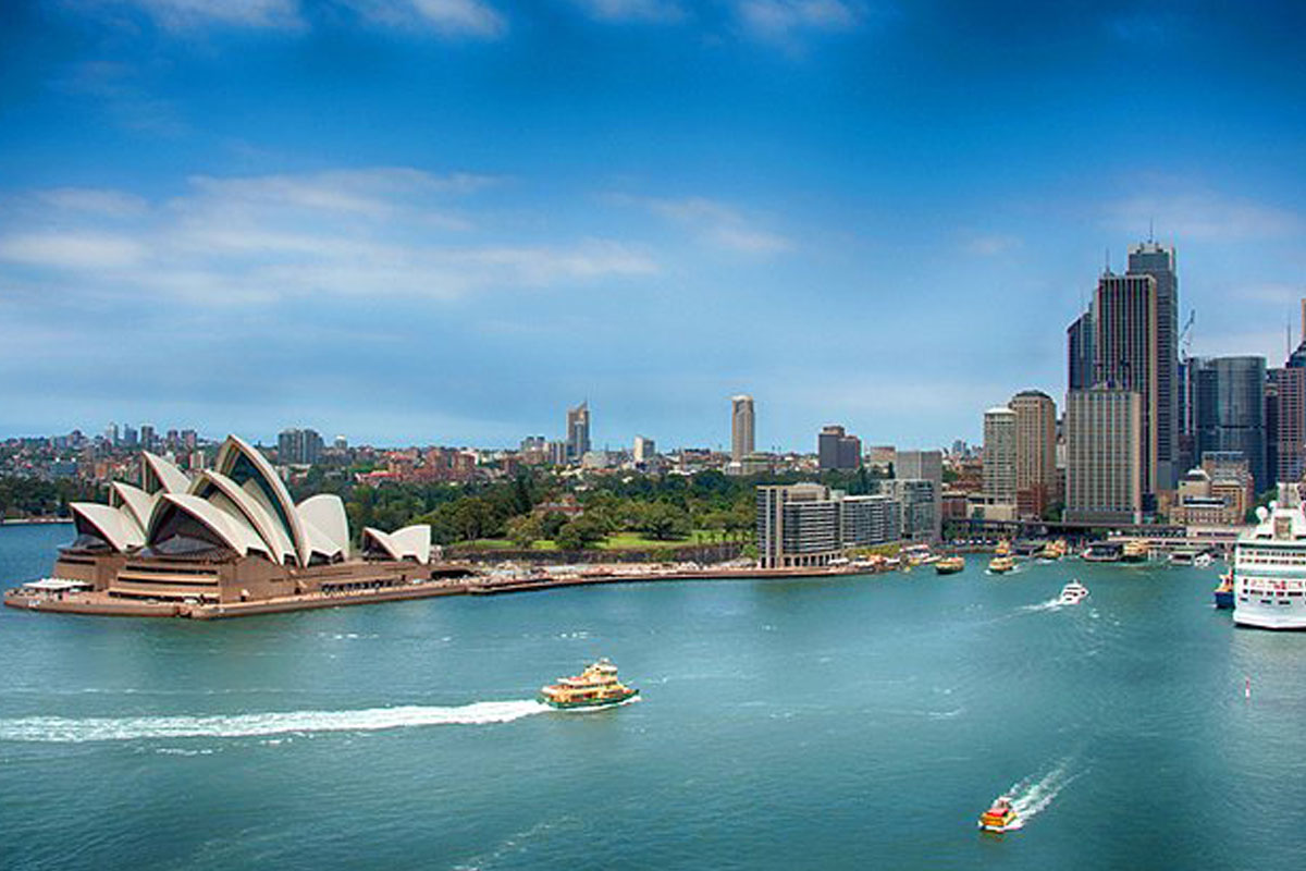 view of Syndey opera house, a harbor, and skyscapers