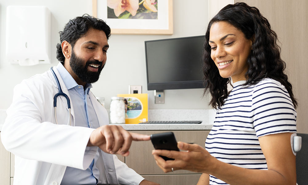 Doctor consult with a patient pointing at the phone screen