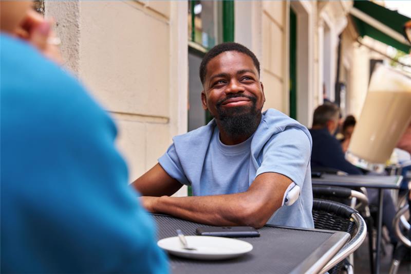 Omnipod Podder sitting outside eating at an outdoor dining table