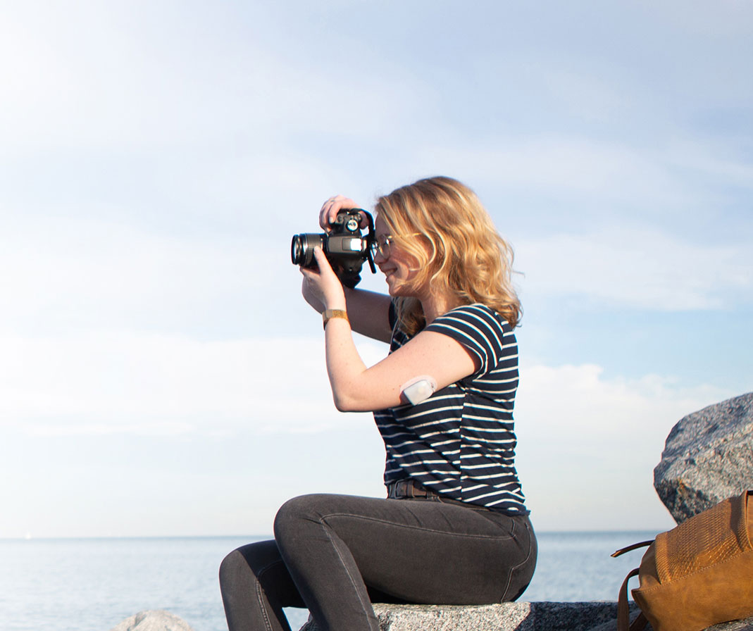 Podder Myrthe taking a photo while sitting on a rock
