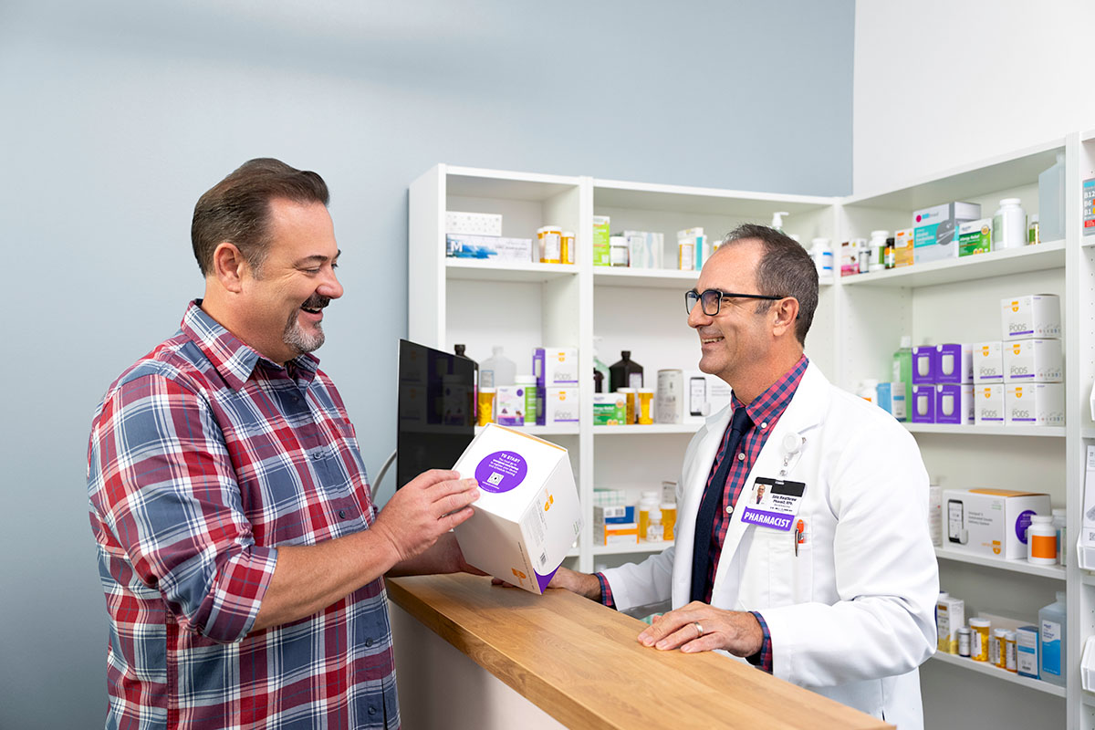 A patient receives Pods from a pharmacist at the pharmacy.