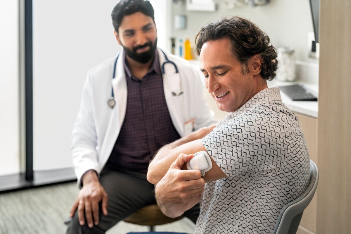 Doktor und Podder tragen und betrachten seinen Omnipod 5