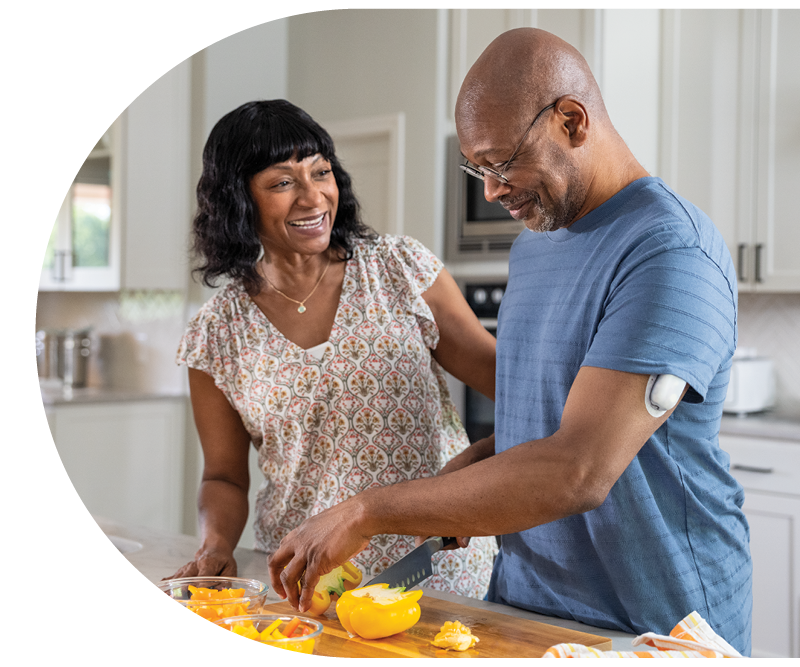 two people in the kitchen chopping vegetables
