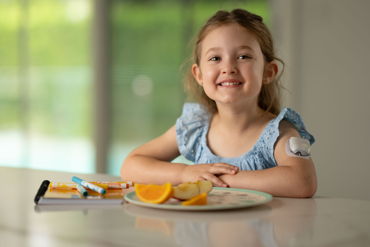 girl sitting at table with a plate of oranges
