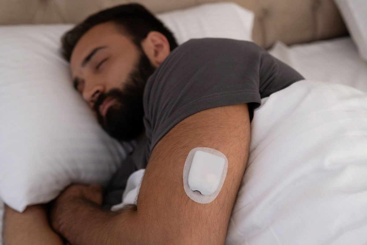 man sleeping and has pod placed on upper arm