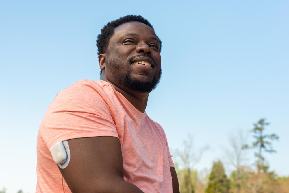 man smiling with a pod on his arm
