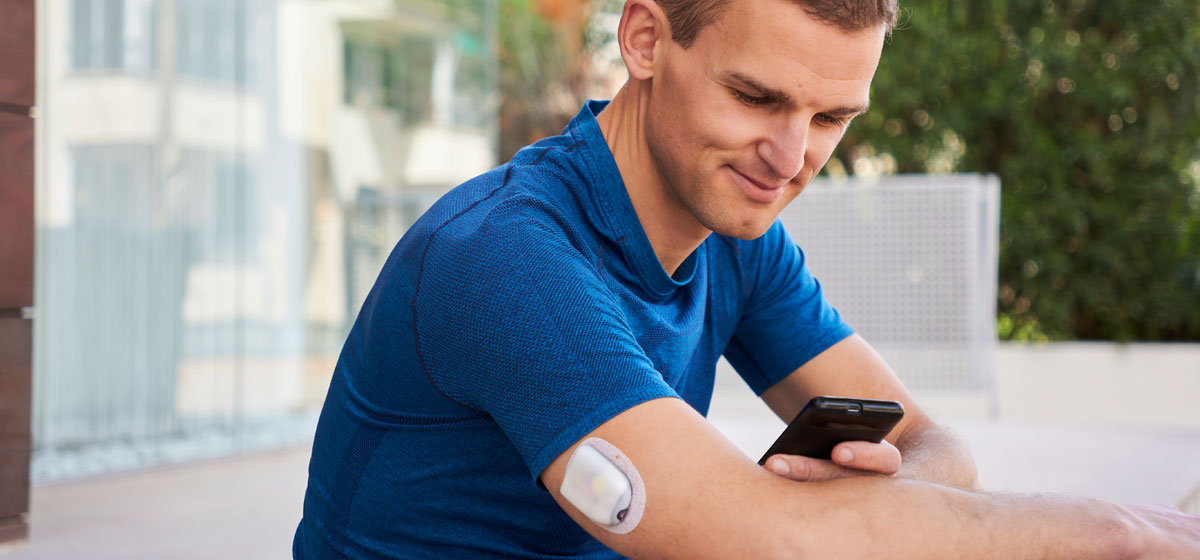man sitting outside and holding a phone 