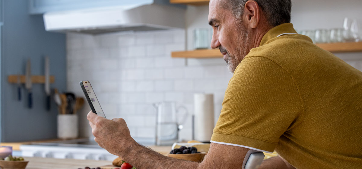 man in kitchen looking at his controller