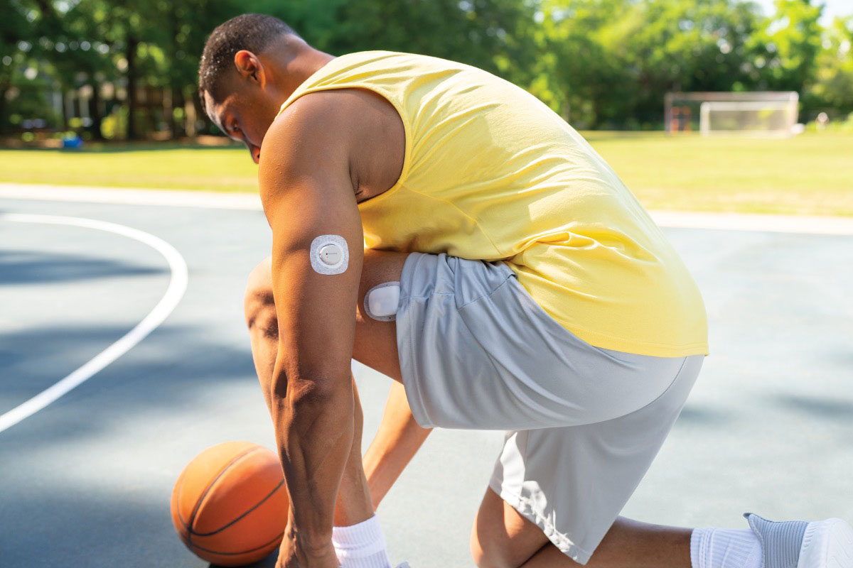 man tying his shoe on a basketball court 