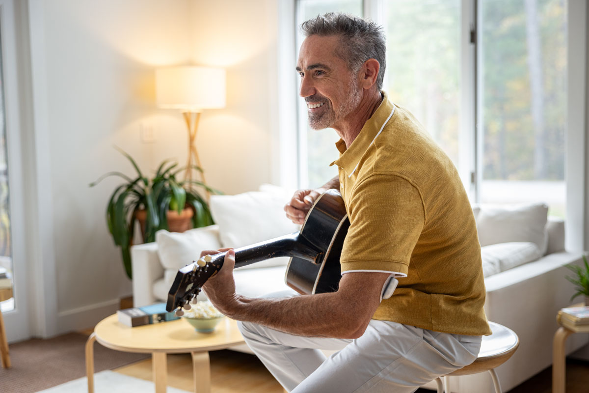 man plating the guitar in a living room