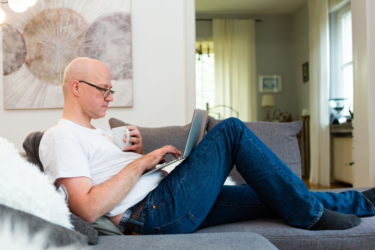 Man sitting on couch while on his laptop