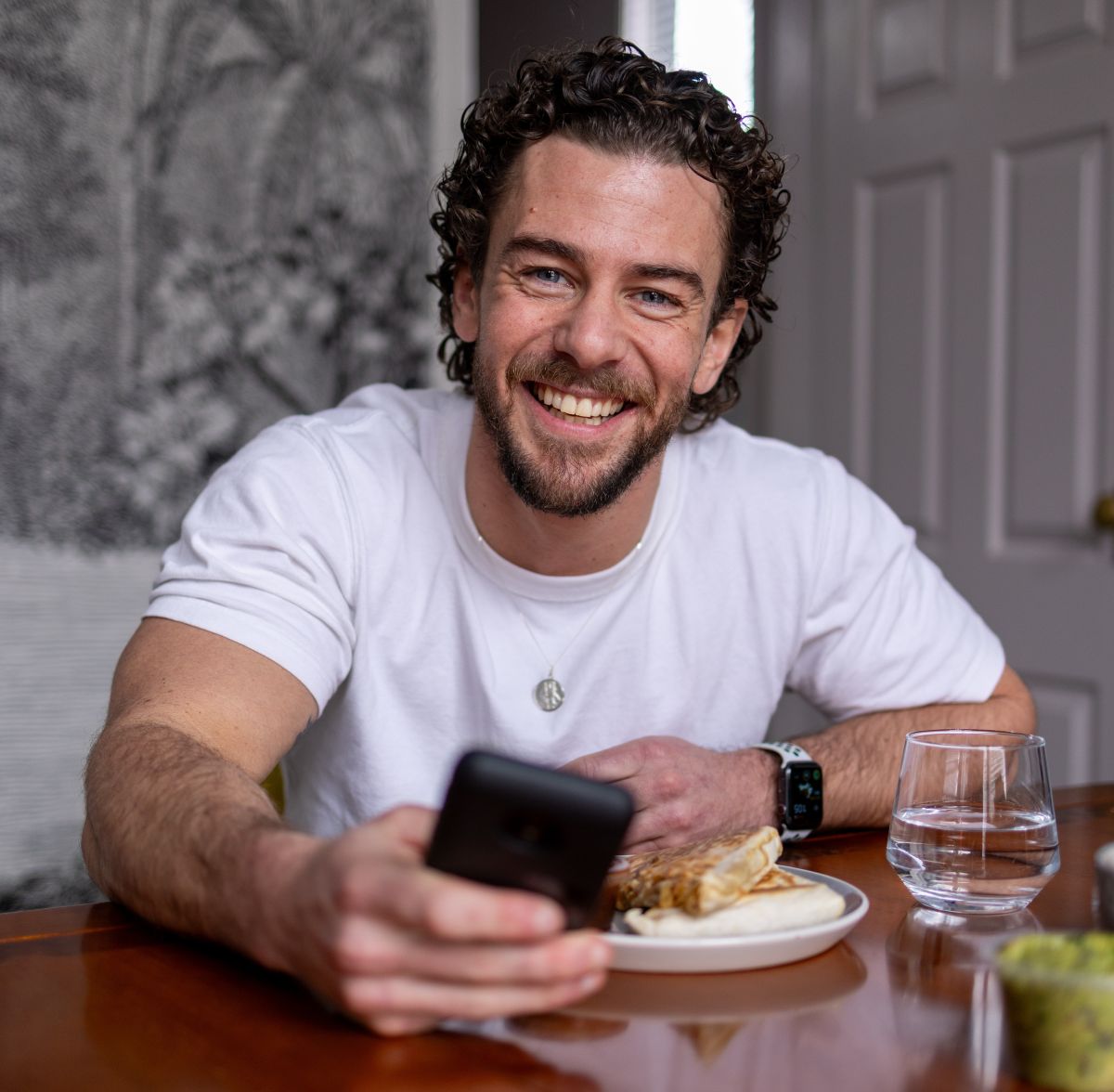 Podder, Rory, sitting at the table with a meal and his phone in his hand