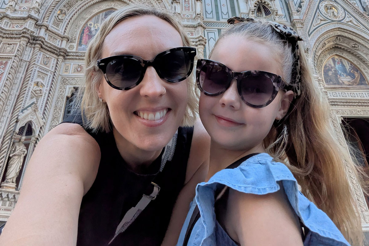 Mom and daughter smiling in front of an ornate church