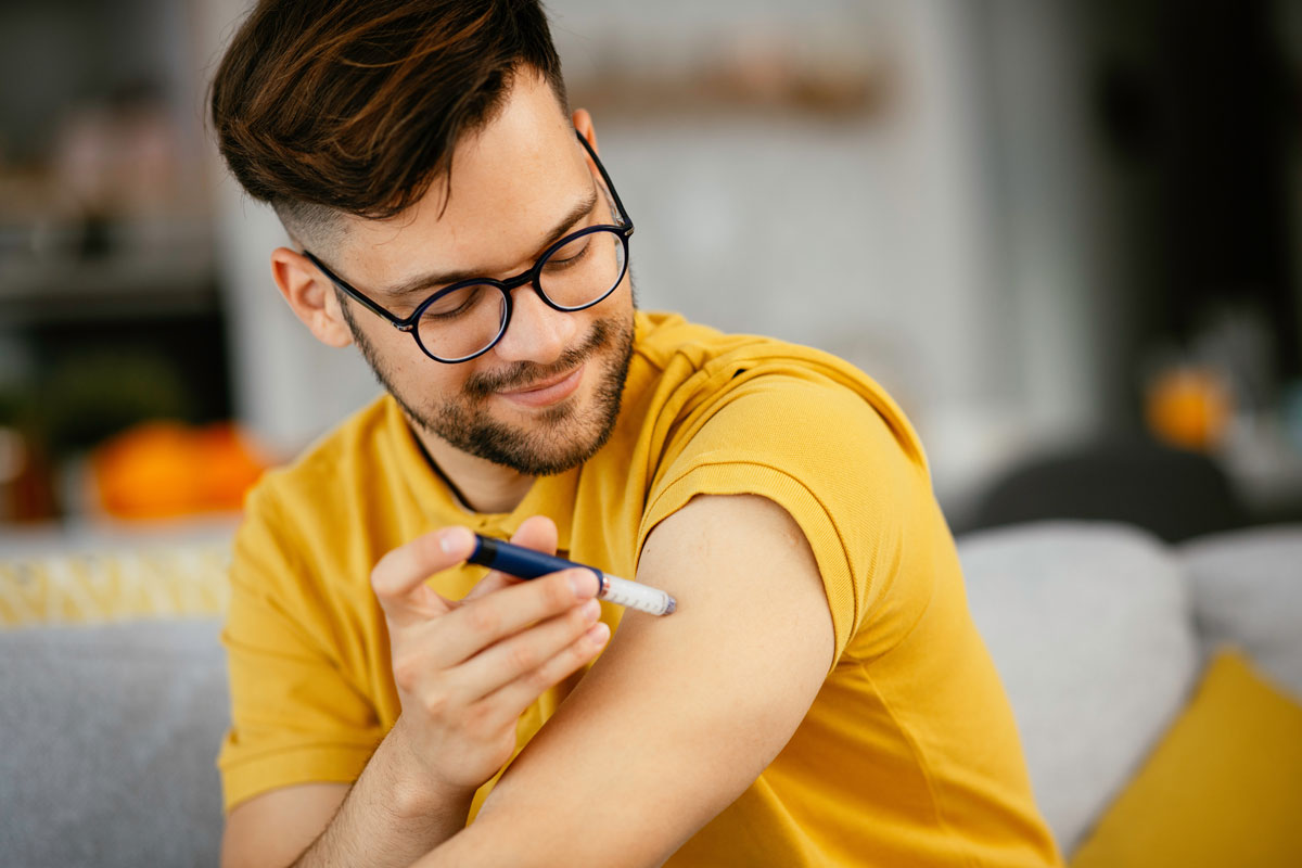 person giving themselves an insulin injection in the arm