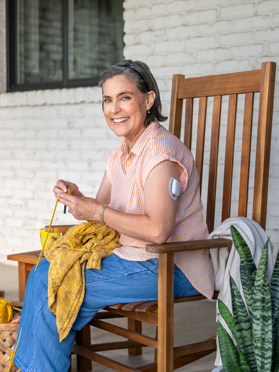 woman sitting on a porch knitting