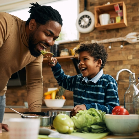 Boy serving his father food from a fork