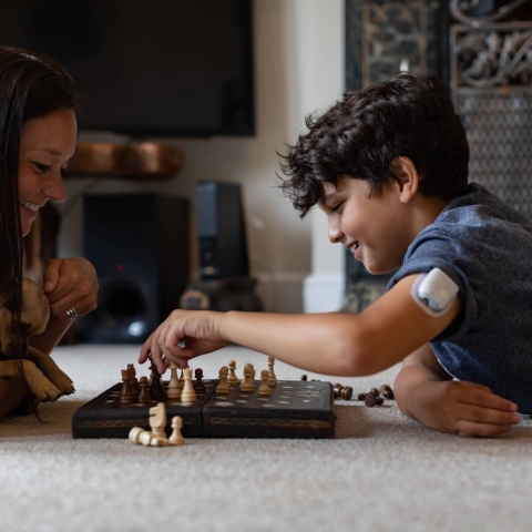 Child playing chess with an adult