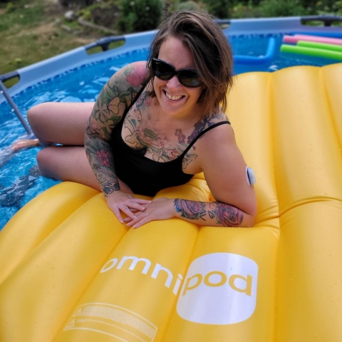 woman with sunglasses sitting on pool floatie
