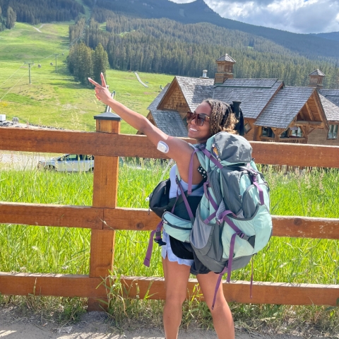Omnipod Podder Lexie Petereson posing for a photo while on a hiking trip with a field of grass in the background