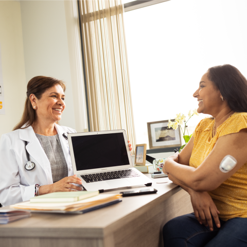HCP and patient sitting at a desk in an office talking