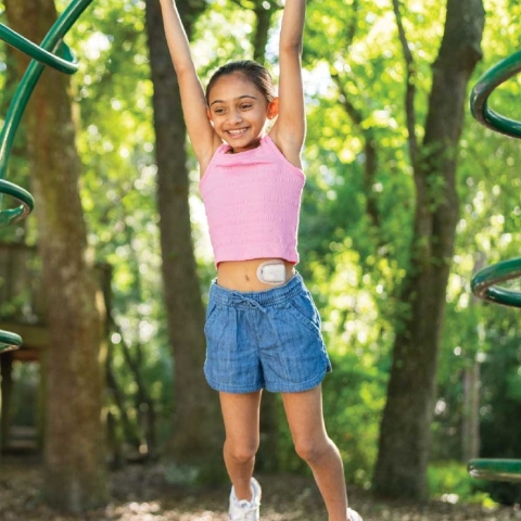 Girl on the monkey bars wearing an Omnipod DASH