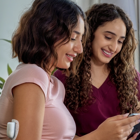 sisters looking at device omnipod