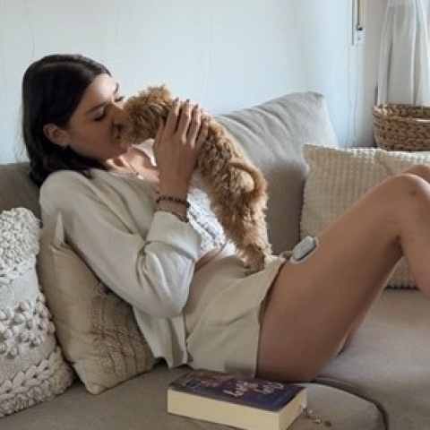 Omnipod Podder, Cindy, sitting on a couch with her dog