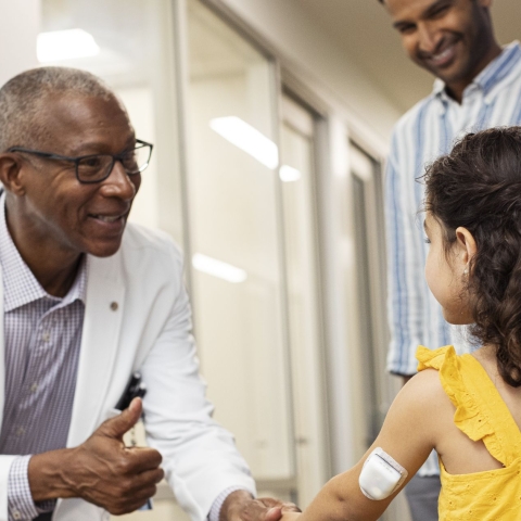 Podder, wearing a device, standing with her Doctor and parents